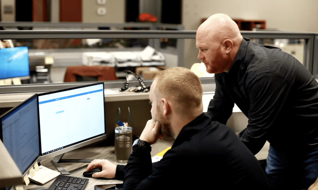 two nots logistics employees working together over a computer